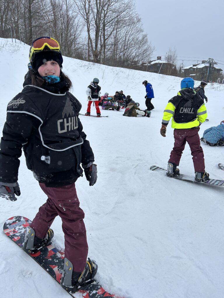 Smiling teenager snowboarding.